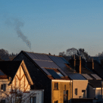 Zonnepanelen op daken van woonhuizen bij zonsondergang, illustratie van hoe lang zonnepanelen mee gaan