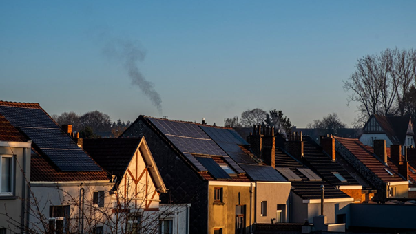 Zonnepanelen op daken van woonhuizen bij zonsondergang, illustratie van hoe lang zonnepanelen mee gaan